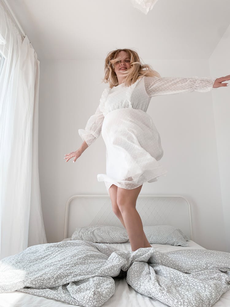 Woman Standing On Bed