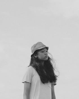 黑白肖像画上，一位戴着帽子的年轻女子看起来若有所思