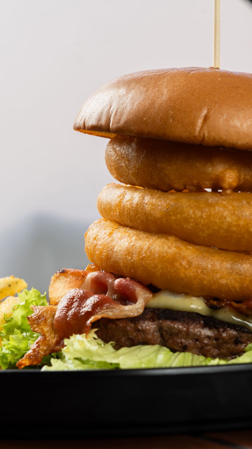 Delicious Gourmet Burger Stack with Onion Rings · Free Stock Photo