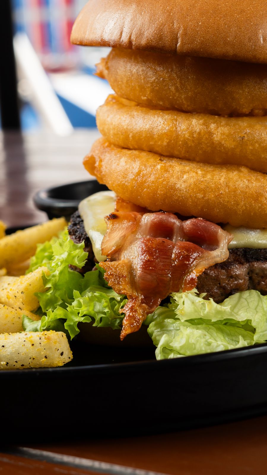 A cheeseburger stacked with crispy onion rings