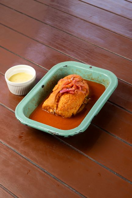 A delicious baked dish served with a creamy sauce, perfect for a hearty meal. — Francesinha, Portugal.