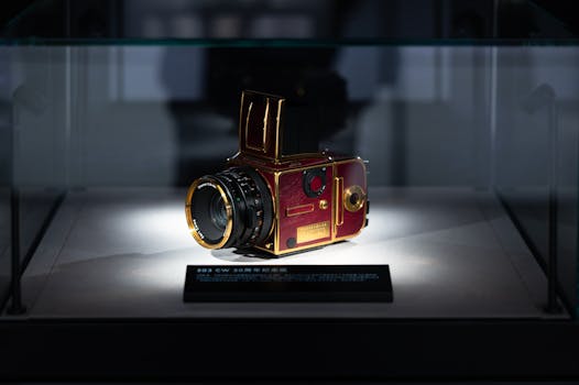 Golden vintage camera elegantly displayed in a museum glass case.