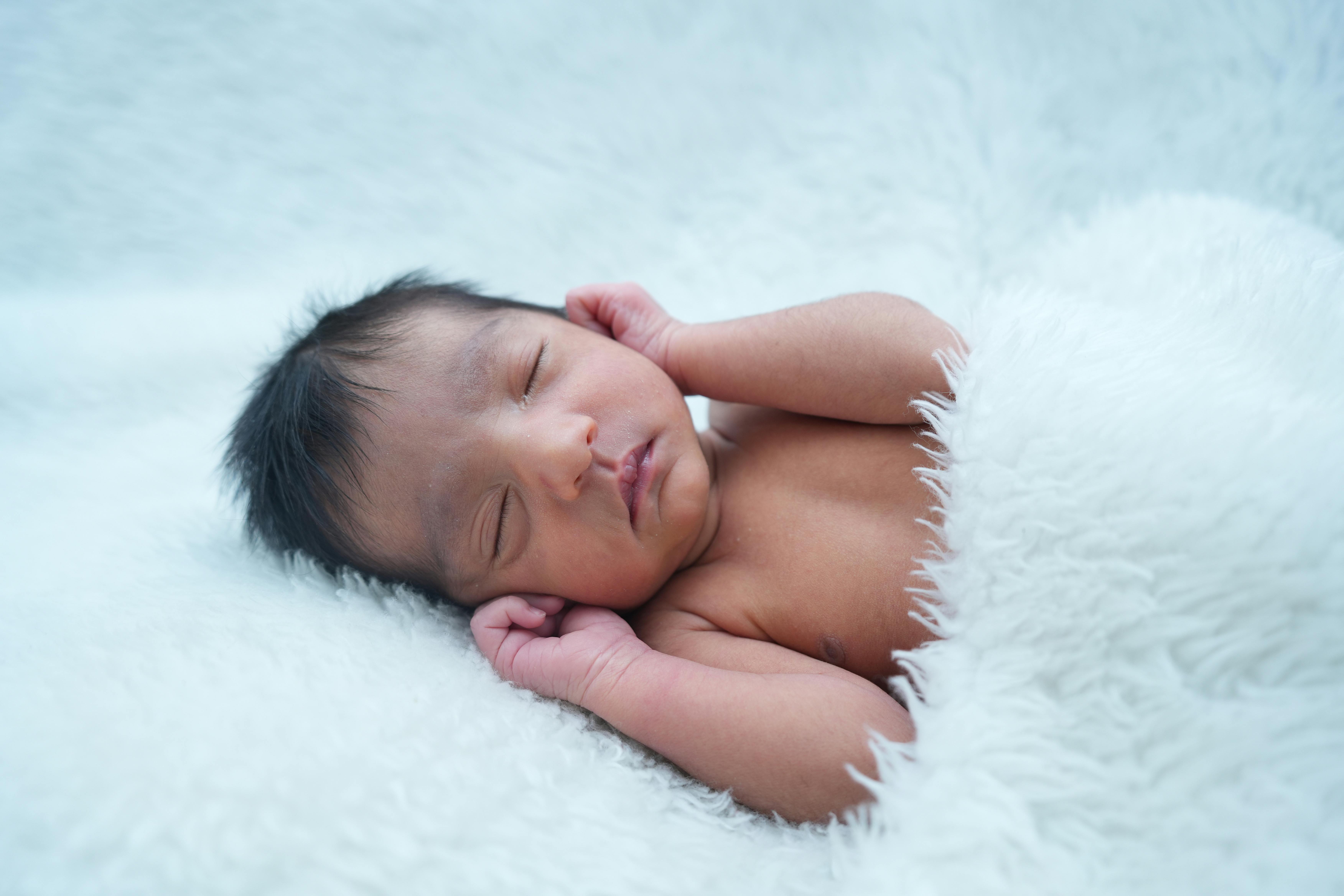 Close-up of a peaceful newborn baby sleeping on a soft, fluffy blanket.