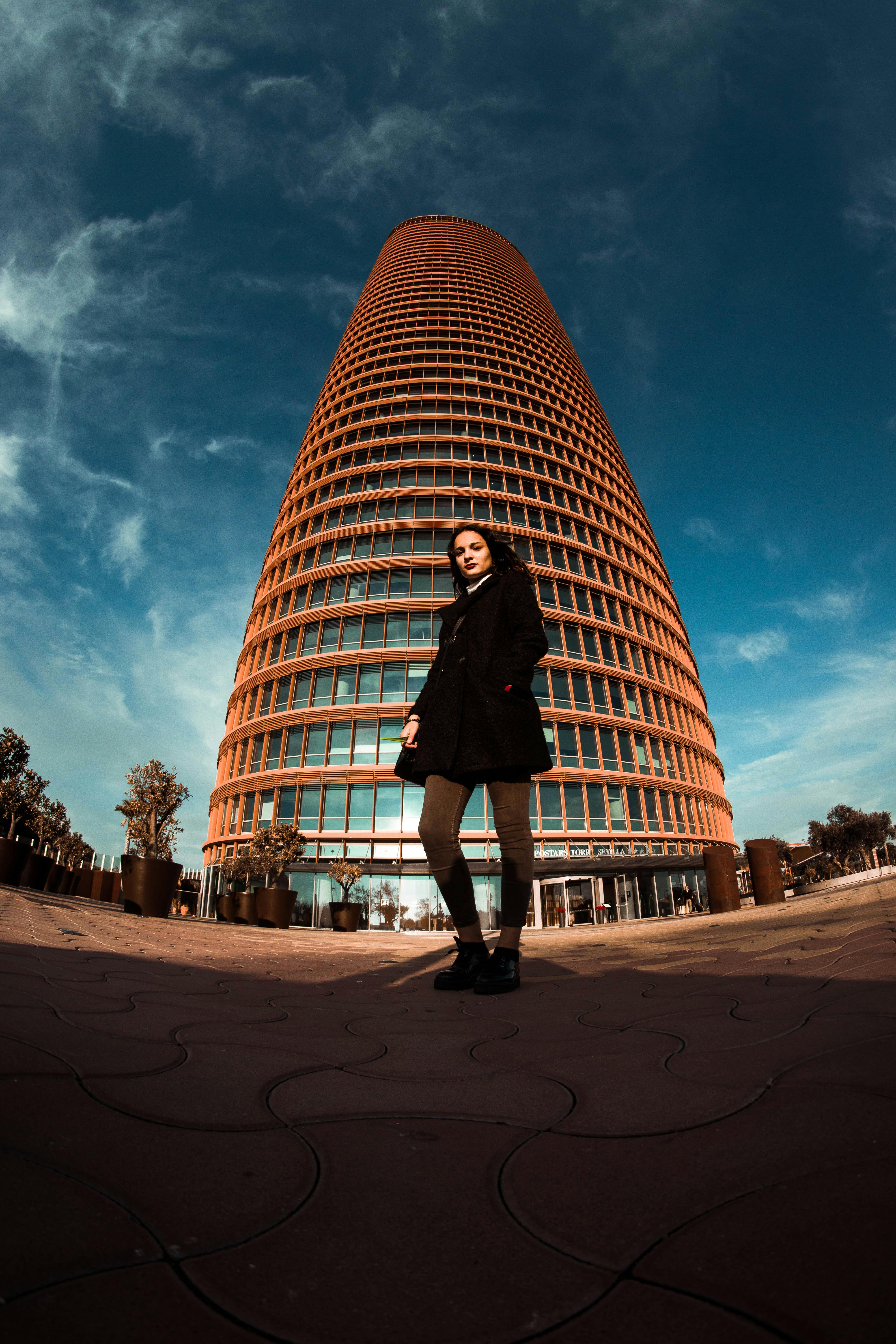 fish eye photography of woman standing in front of tall building