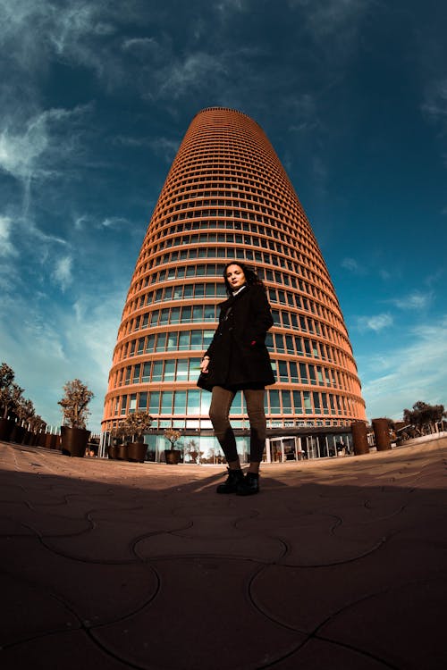 Fotografia Fish Eye Di Donna In Piedi Davanti A Un Edificio Alto