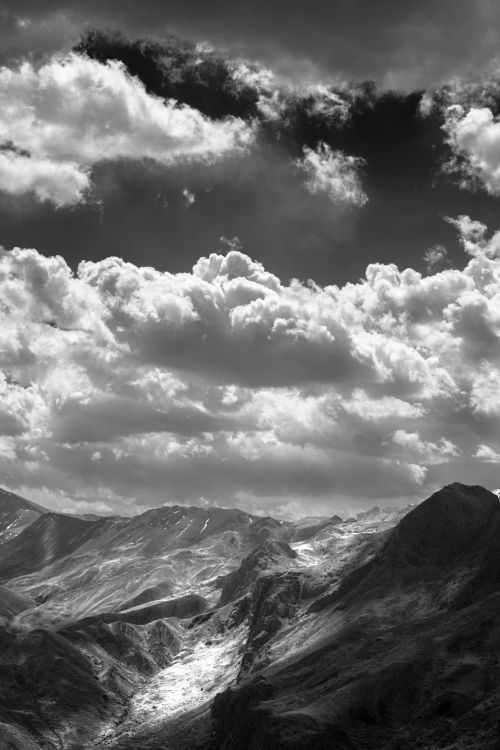 Free A stunning black and white photo of mountains under a cloudy sky. Stock Photo