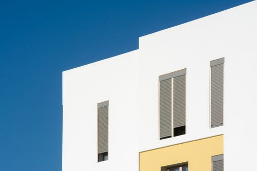 Free Clean modern architecture with a bright facade against a clear blue sky. Stock Photo