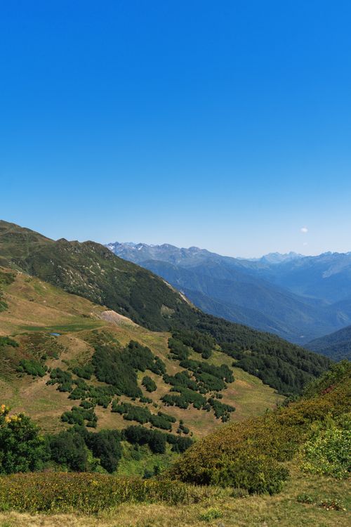 Free Breathtaking panoramic view of lush green mountains under a clear blue sky in Гагра. Stock Photo