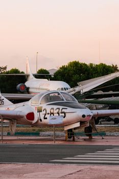 Two vintage aircraft on display in an outdoor aviation museum setting during sunset.
