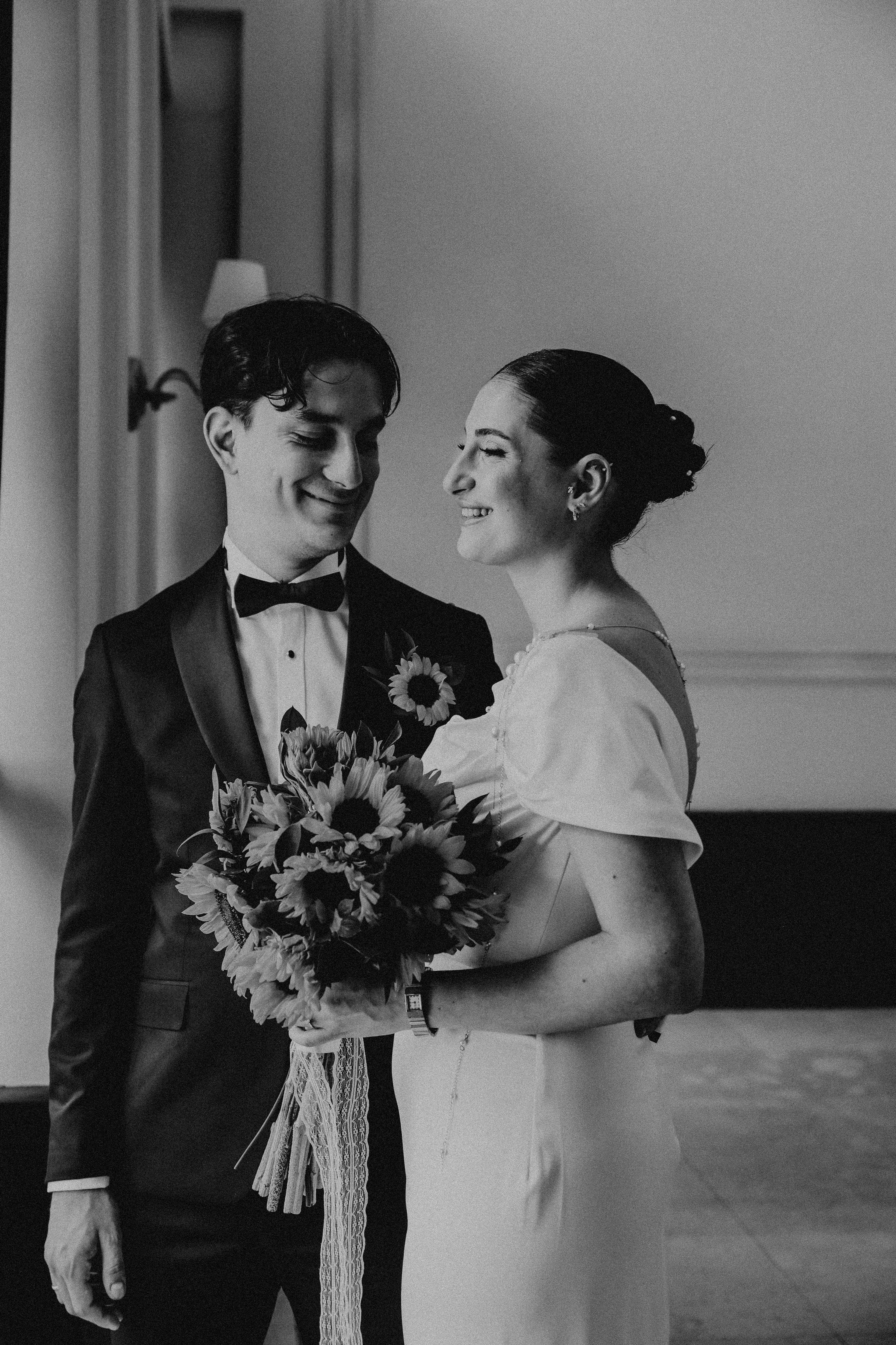 Charming couple in a classic black and white wedding portrait indoors.