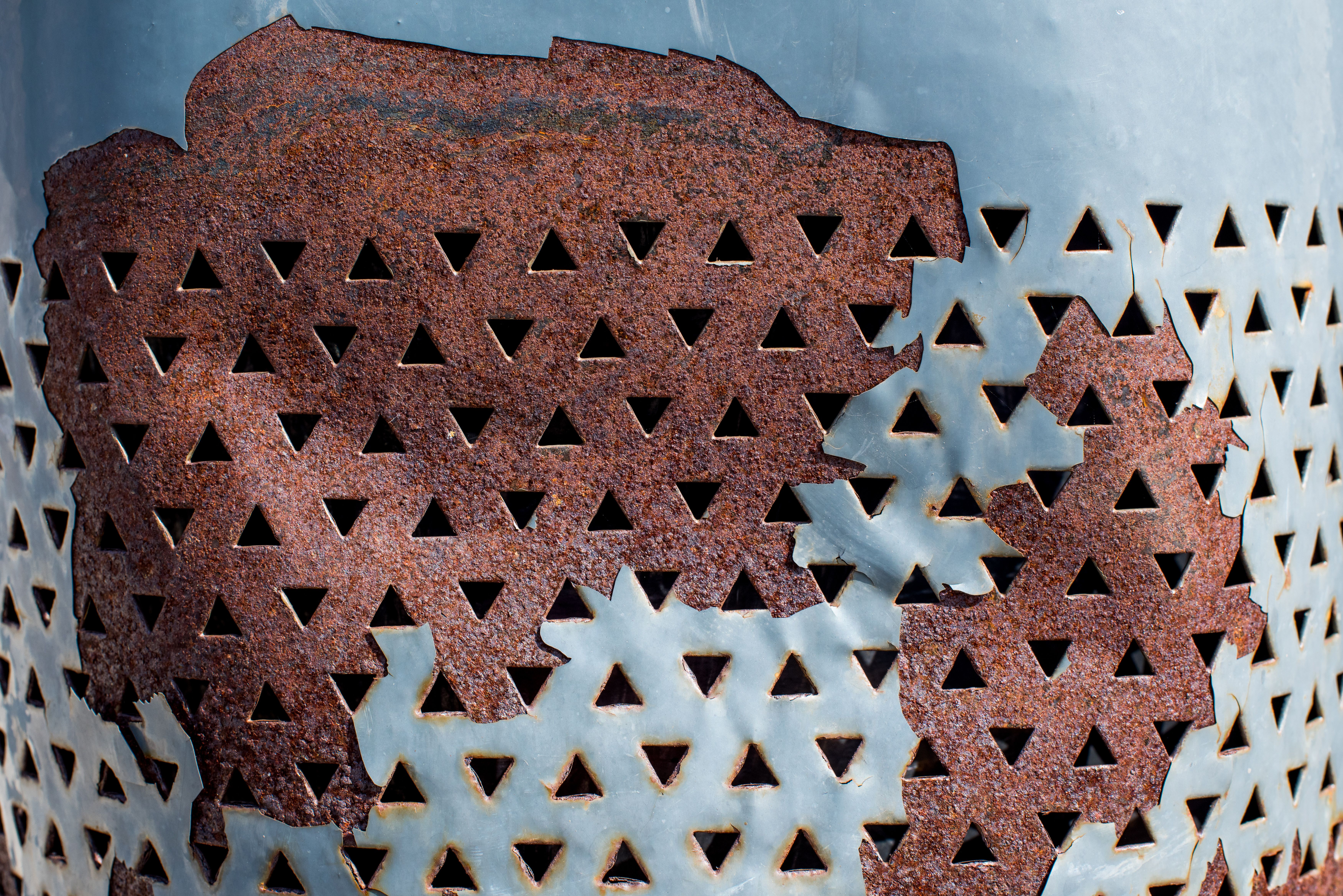 Close-up of Rusting Metal with Triangle Holes · Free Stock Photo