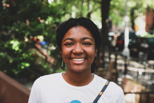 Free Portrait of a smiling young woman enjoying a sunny day in New York City. Stock Photo