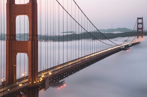 Free Golden Gate Bridge enveloped in fog during dawn, showcasing its iconic structure. Stock Photo