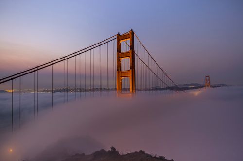 Free Iconic view of the Golden Gate Bridge enveloped in mist at dawn, highlighting its structure. Stock Photo