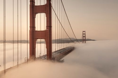 Free A stunning view of the Golden Gate Bridge enveloped in dense morning fog, creating a serene scene. Stock Photo