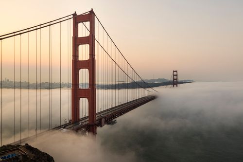 Free Stunning view of the Golden Gate Bridge enveloped in fog during sunrise. Stock Photo