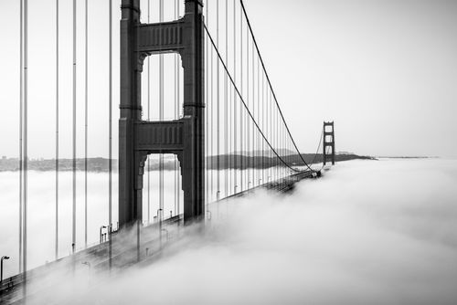 Free Black and white photo of Golden Gate Bridge enveloped in fog, creating a dreamlike scene. Stock Photo