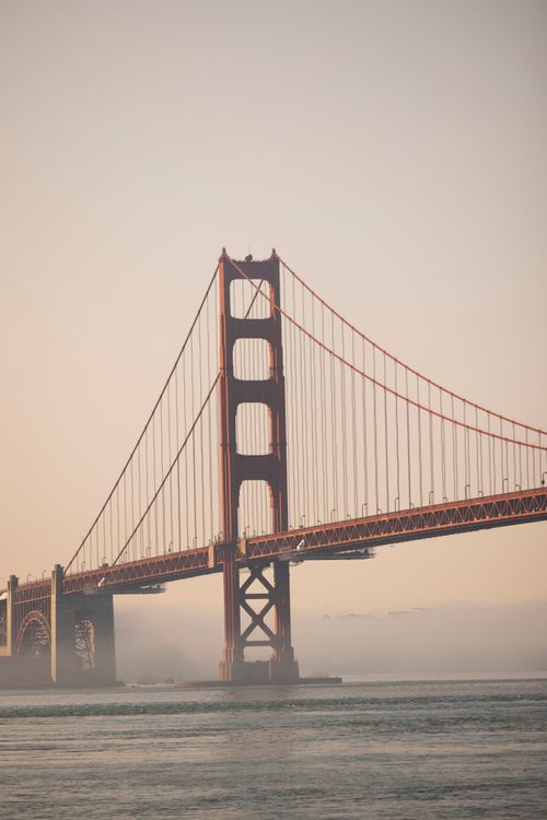 Free Iconic Golden Gate Bridge with morning fog and calm waters in San Francisco. Stock Photo