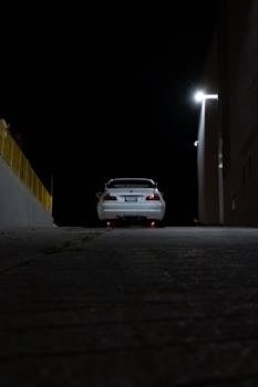 Dramatic night photograph of a BMW without a visible license plate, highlighted in an alley, Ontario, Canada.