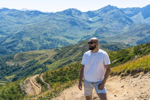 A man hiking in the scenic Caucasus Mountains in Гагра, enjoying the summer views.