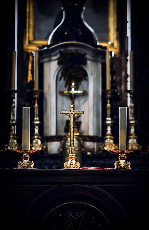 Free Ornate altar with golden candle holders and crucifix, reflecting religious symbolism in a church setting. Stock Photo