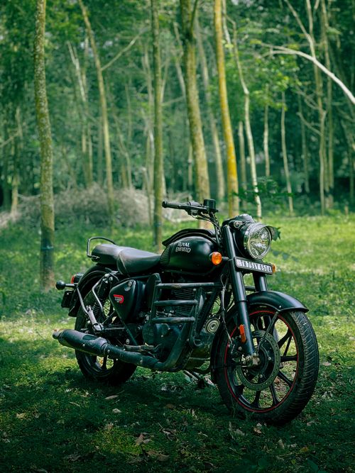 Free A classic motorcycle parked in a lush forest setting in Kanniyakumari, India. Stock Photo