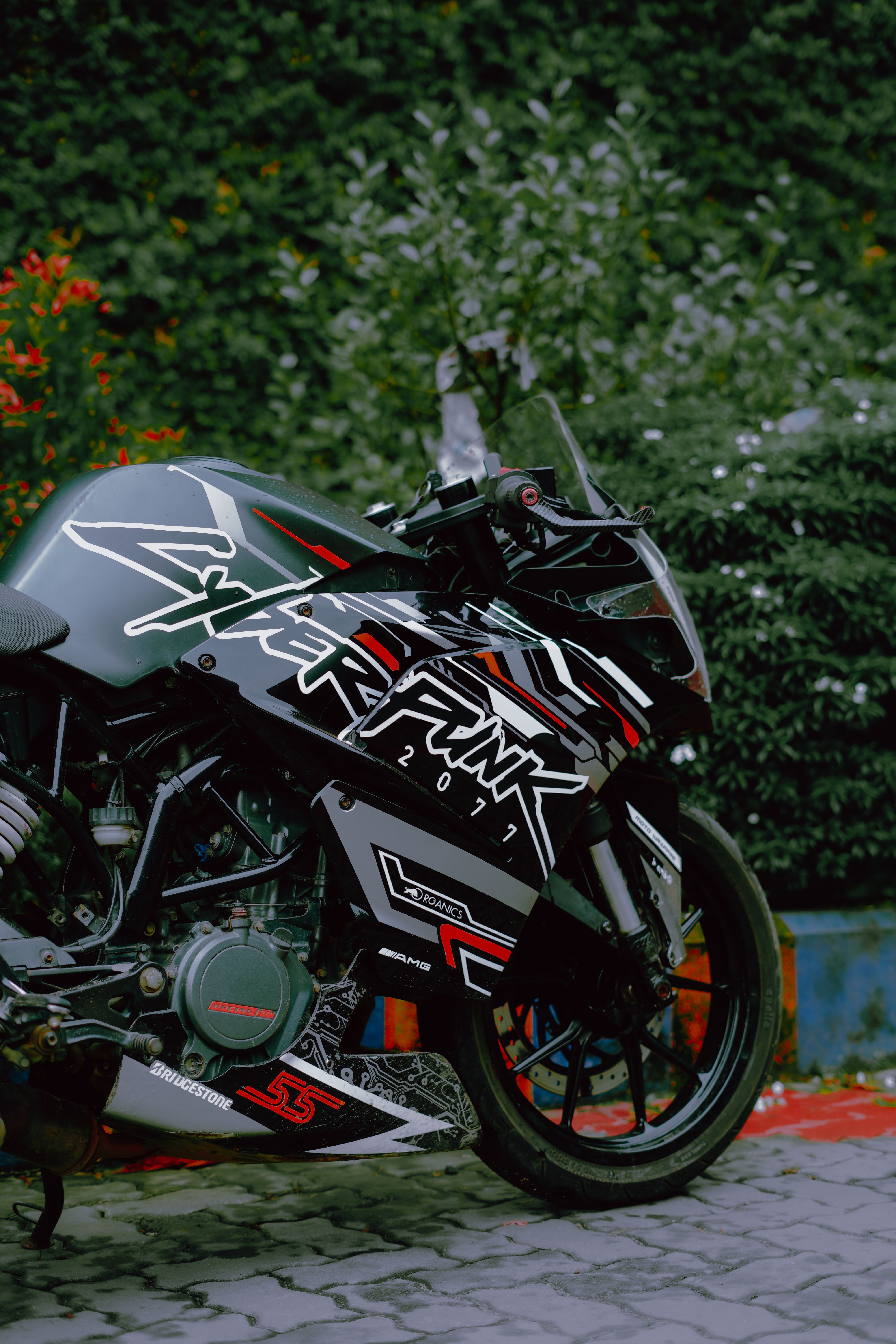 A sleek cyberpunk-themed motorcycle parked outdoors against greenery.