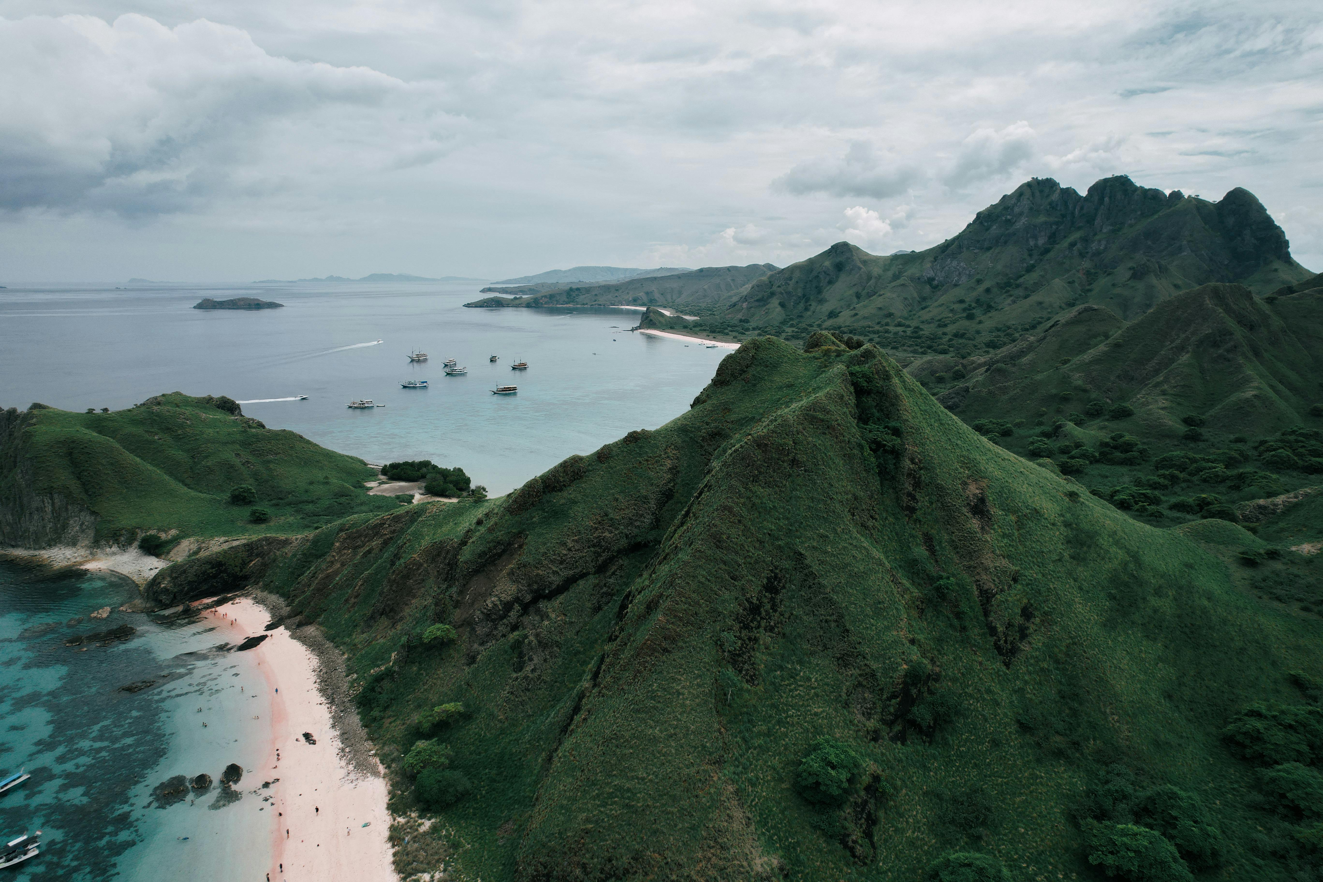 Aerial view of Padar Island in Labuan Bajo showcasing rugged hills, winding trails, and turquoise waters surrounding three distinct bays.