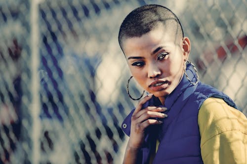 Photo Of Woman Standing Near Chain Link Fence