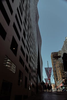 蔚蓝天空下，低角度视角中的城市景观与现代摩天大楼