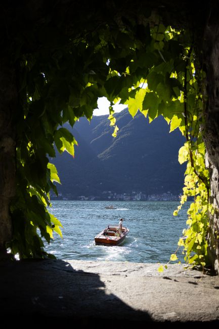 A serene wooden boat on a picturesque lake framed by lush greenery.