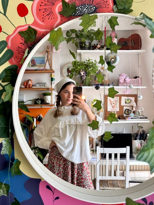 Free Young woman takes a selfie in a creatively decorated room with plants and art. Stock Photo