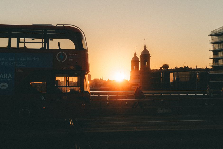 Silhouette of London Bridge with a bus and sunset view.
