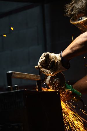 Industrial worker grinding metal in a workshop