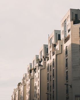 Elegant row of urban apartment buildings under a warm sunset sky.