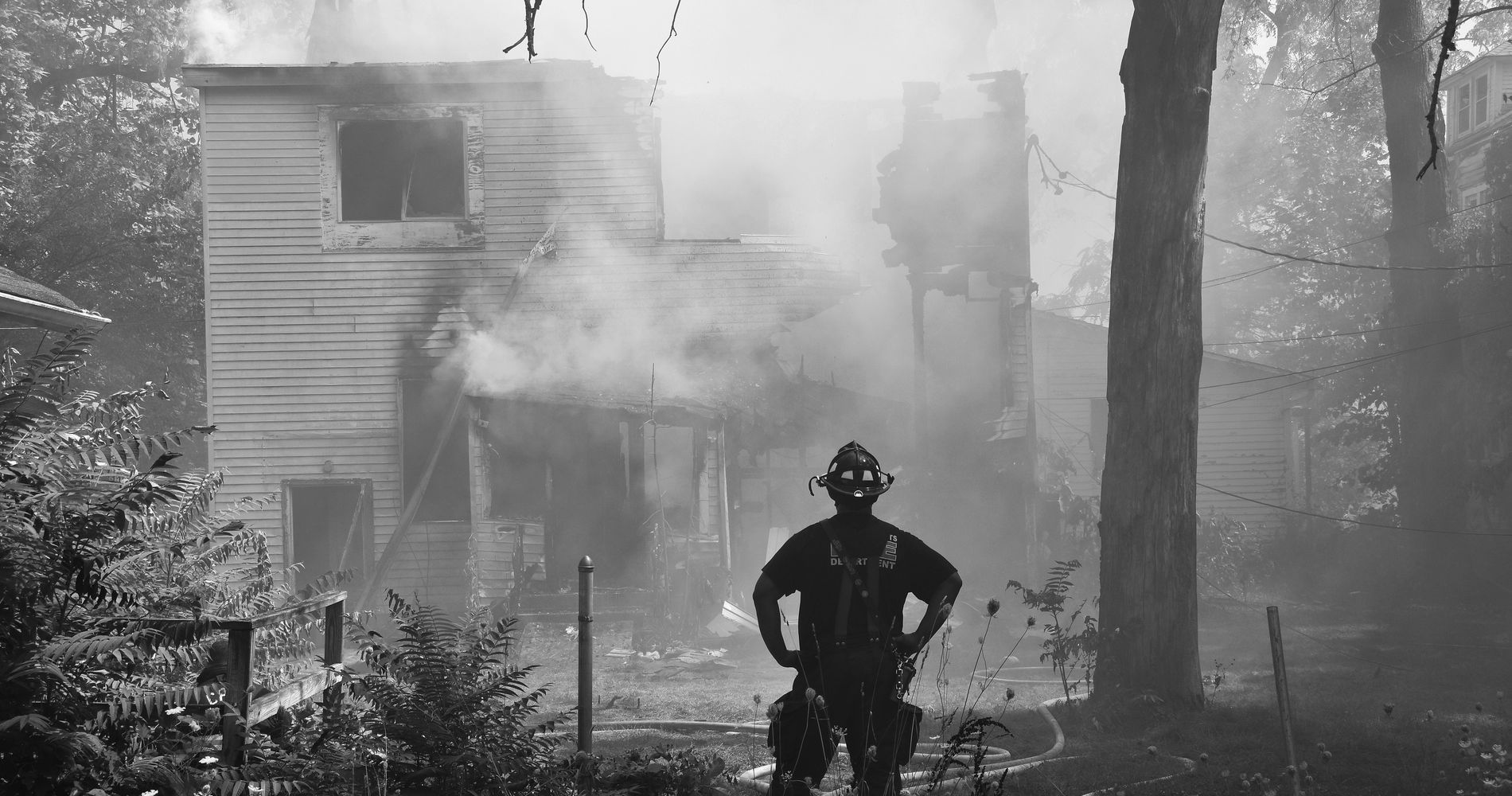Firefighter assessing a smoke-damaged house