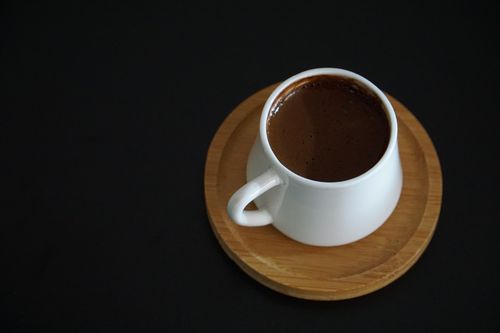 Free A classic Turkish coffee in a white cup on a wooden saucer, minimal and elegant. Stock Photo