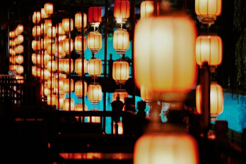 Free Vivid display of traditional lanterns glowing at night with soft reflections. Stock Photo
