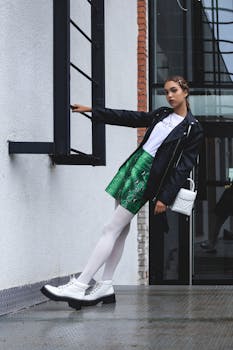 Fashionable woman in urban setting with bold style and edgy pose.