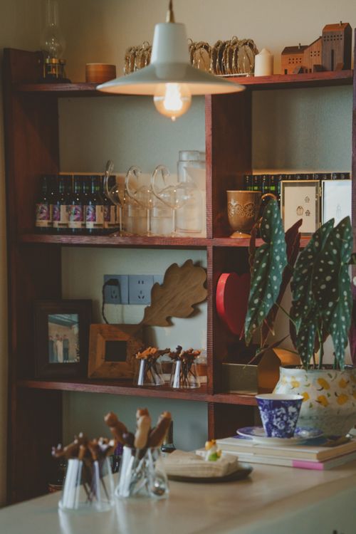 Free Warm indoor cafe setting with decorative shelves, plants, and soft lighting. Stock Photo