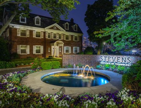Illuminated view of Stevens Institute of Technology with a fountain at night, Hoboken, NJ.