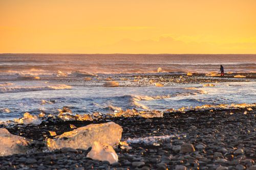 Free Golden sunset over Iceland's ice beach, showcasing tranquil waves and ice formations. Stock Photo
