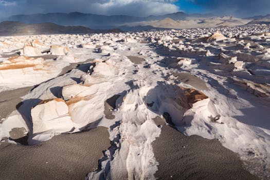 Explore the stunning eroded rock formations of the Atacama Desert under a dramatic sky.