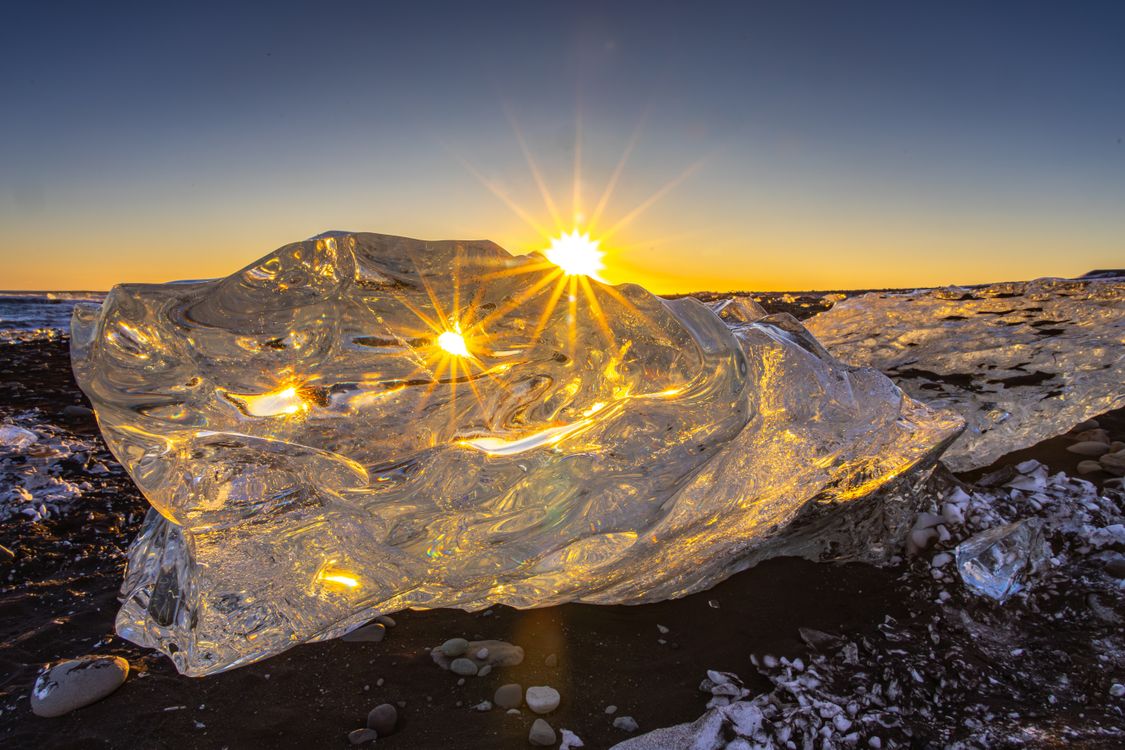 Sun Rising Ice Mesmerizing Sunrise Behind Ice Block on Icelandic Beach · Free Stock Photo