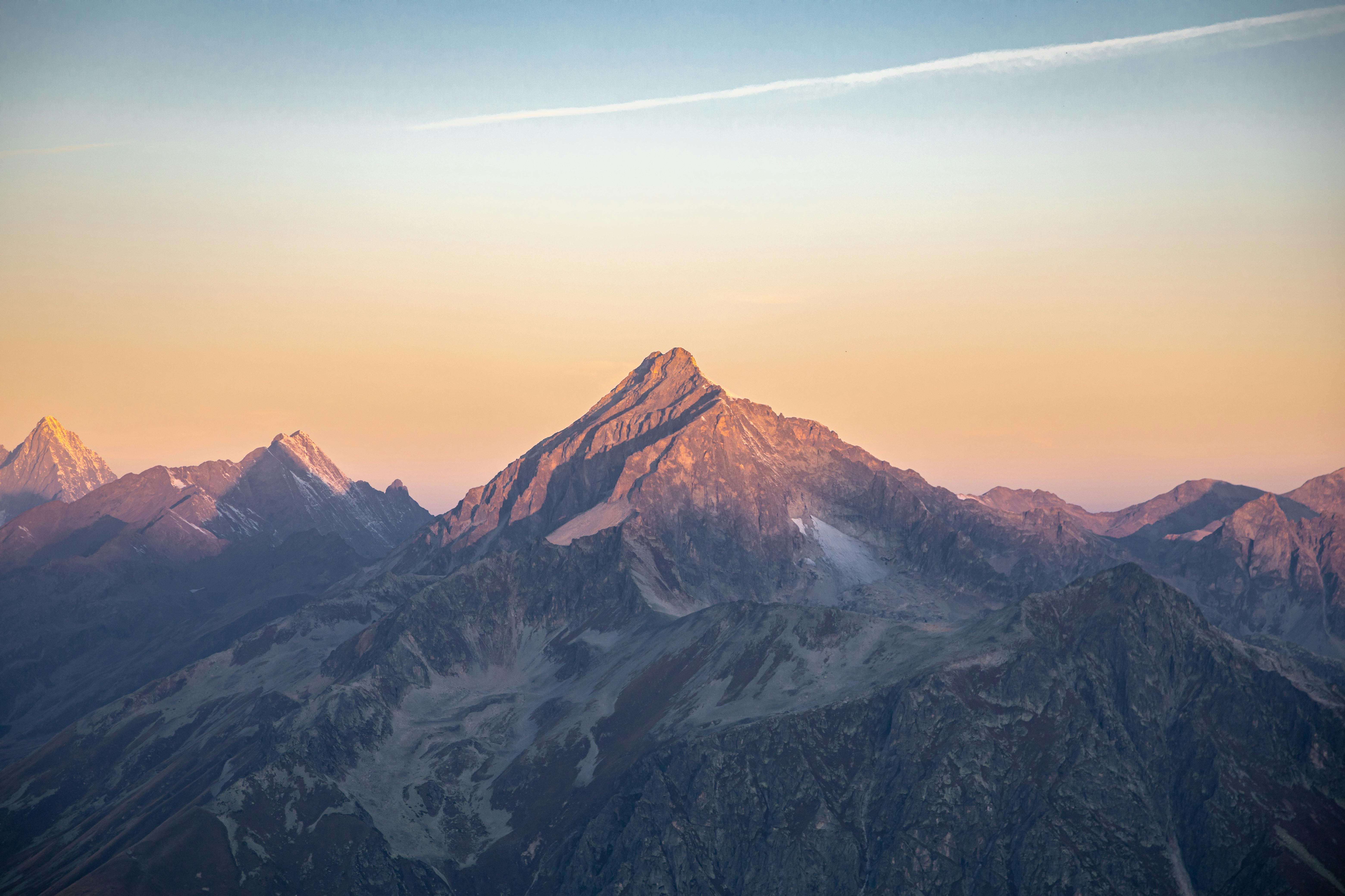 Breathtaking view of mountain range illuminated by soft sunrise colors, showcasing nature's beauty.