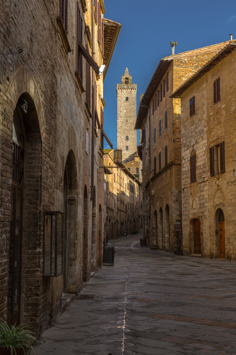 Alee medievală îngustă din piatră în San Gimignano, Toscana