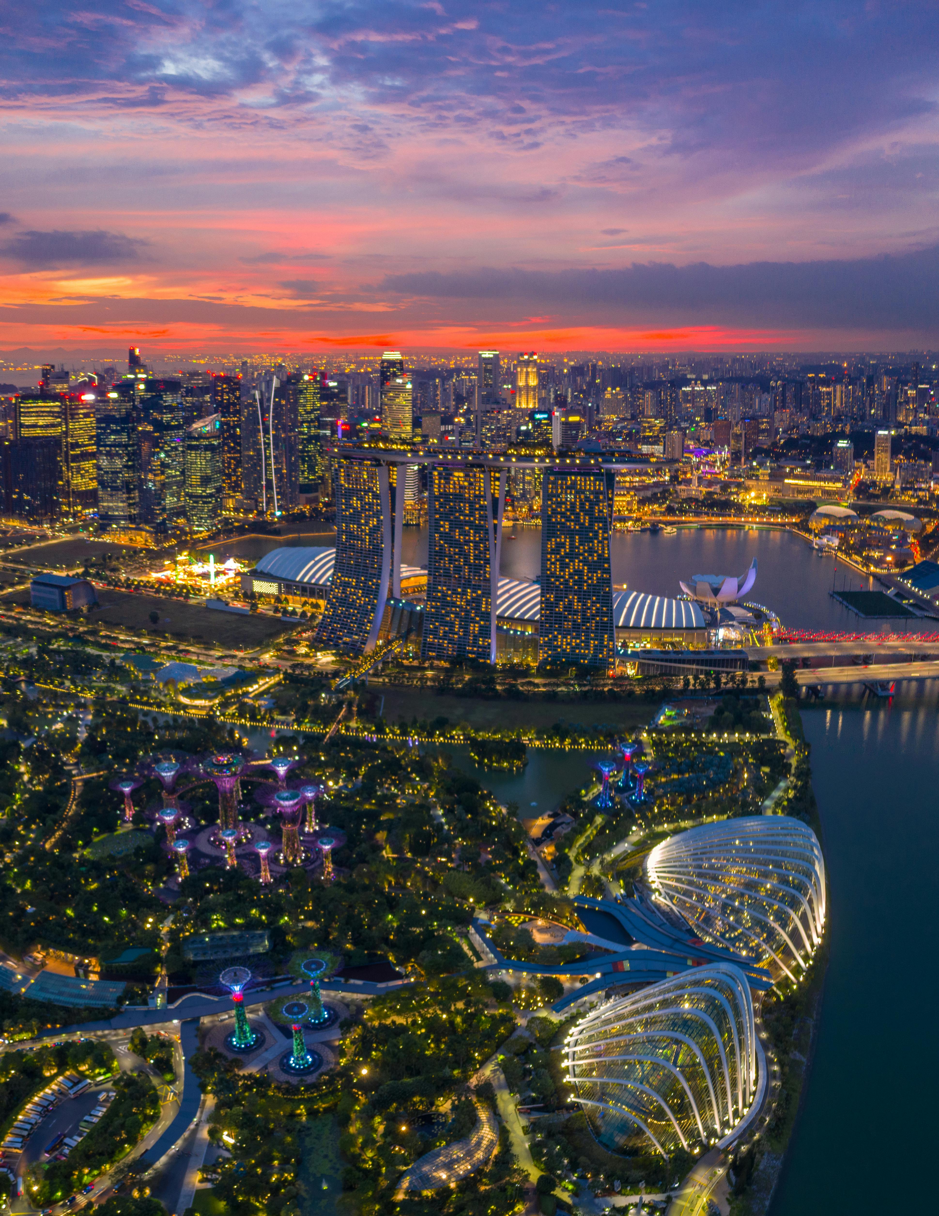 Aerial view of Singapore's Marina Bay skyline with shophouse rooftops in the foreground at golden hour