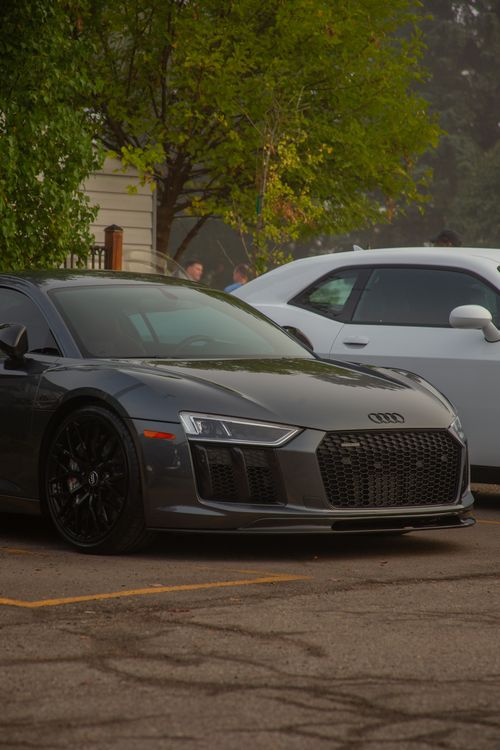 Free A sleek black Audi sports car parked outdoors in an urban area, showcasing modern design. Stock Photo