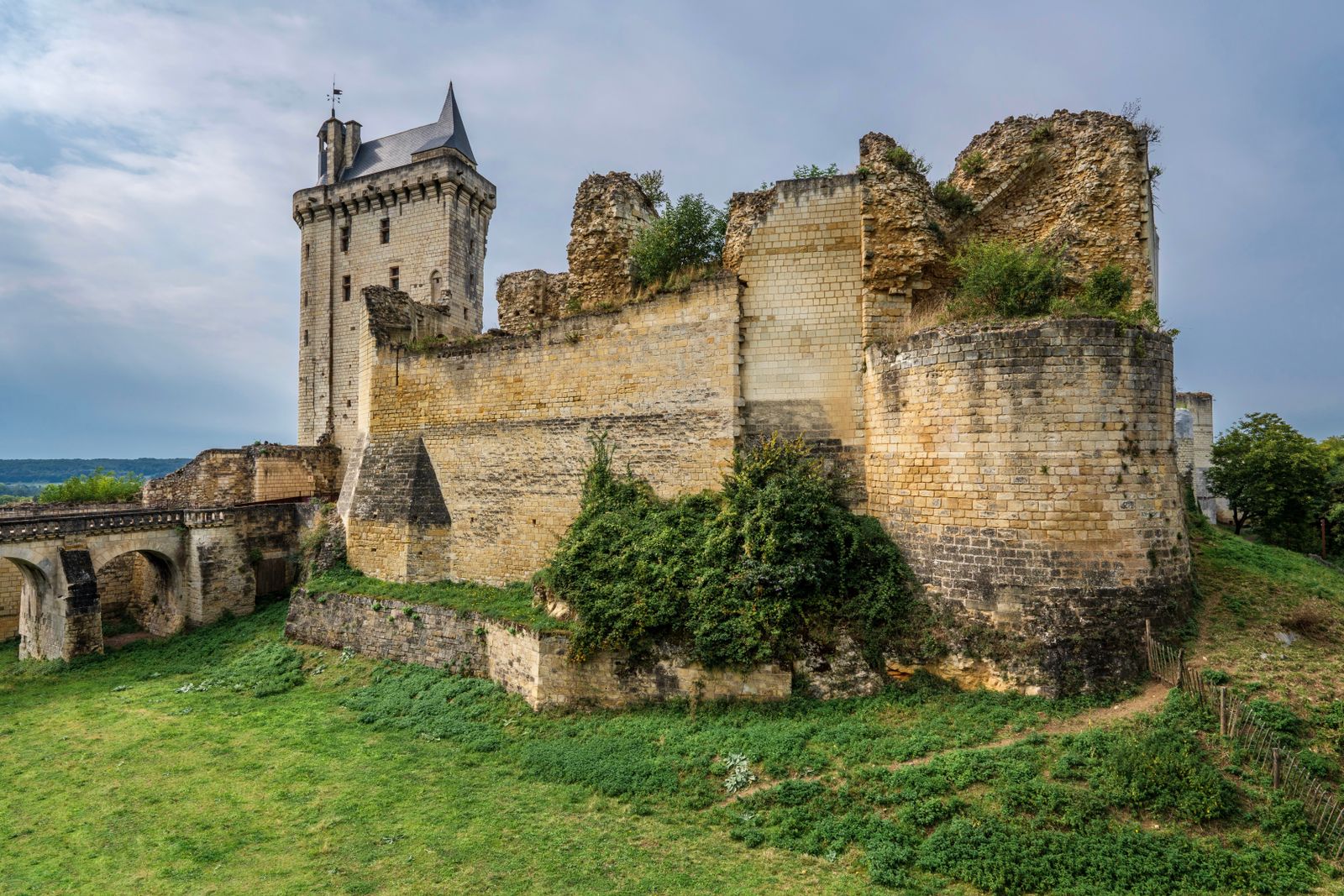 Château de Chinon sous un ciel pluvieux, pierre claire et nuages bas, ambiance médiévale humide