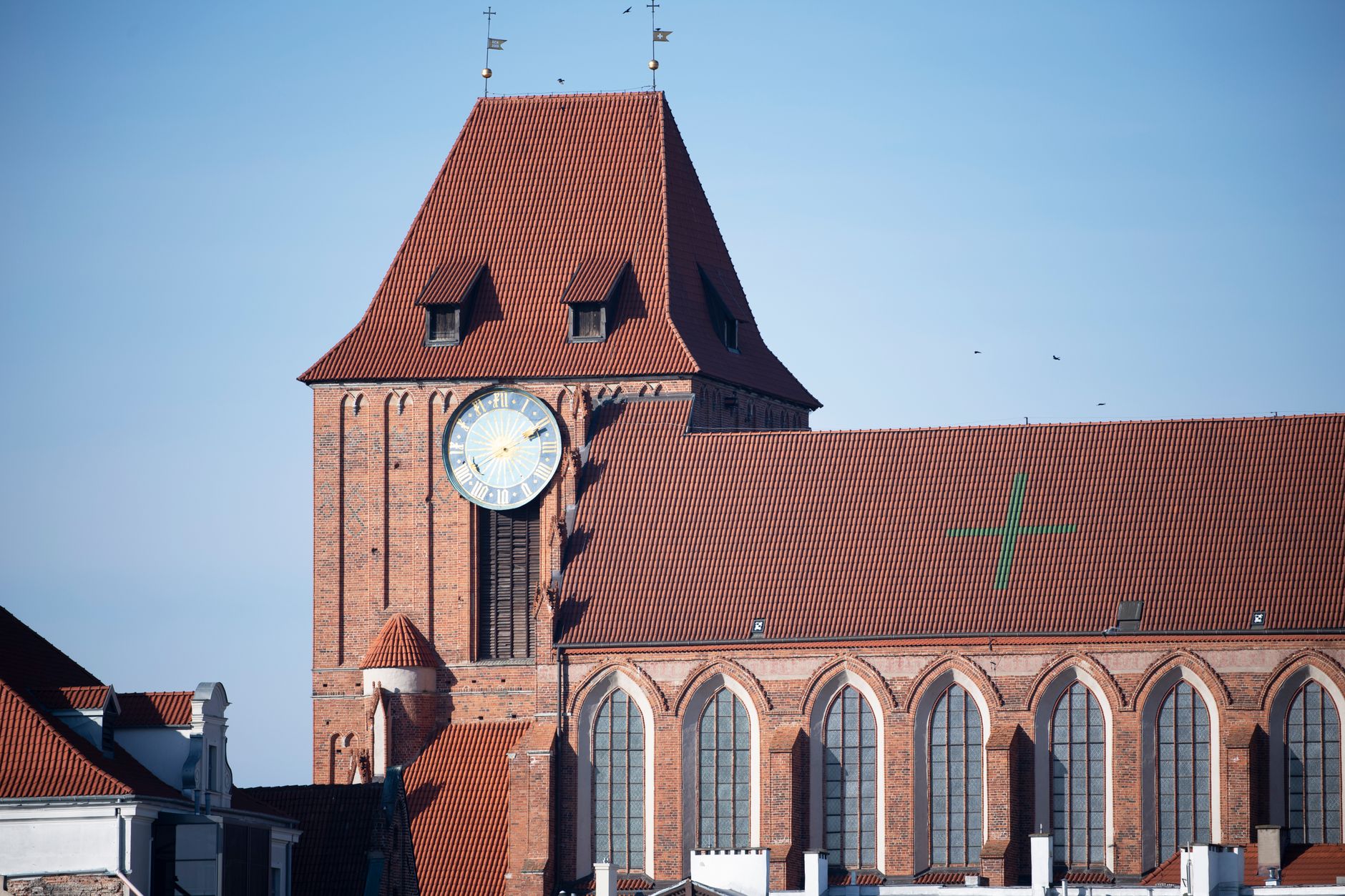 Close-up of a historic Gothic church tower with a clock and red brick architecture.